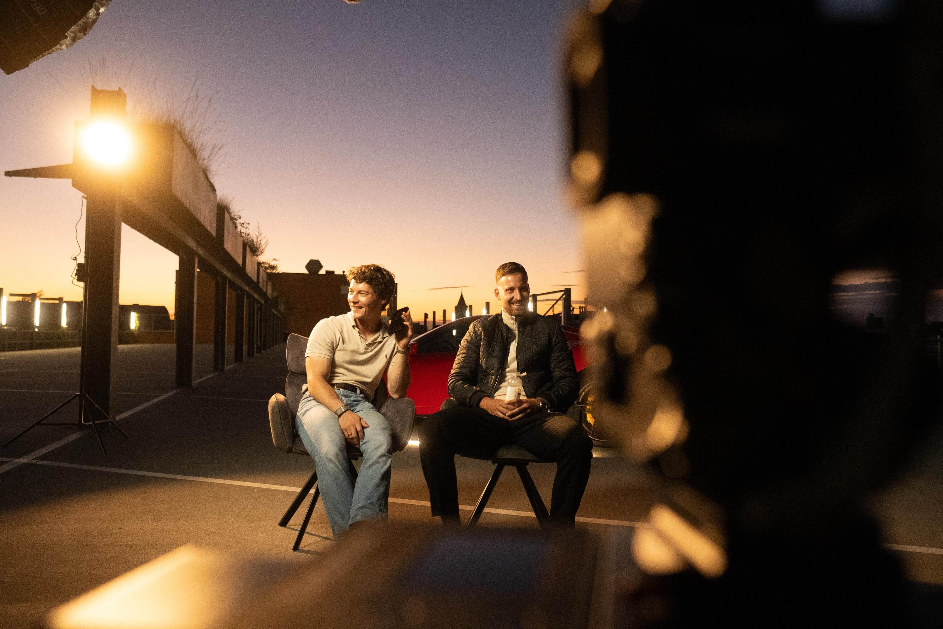 Cedric Ruppenthal mit einem Kunden beim Dreh auf einem Parkdeck bei Sonnenuntergang