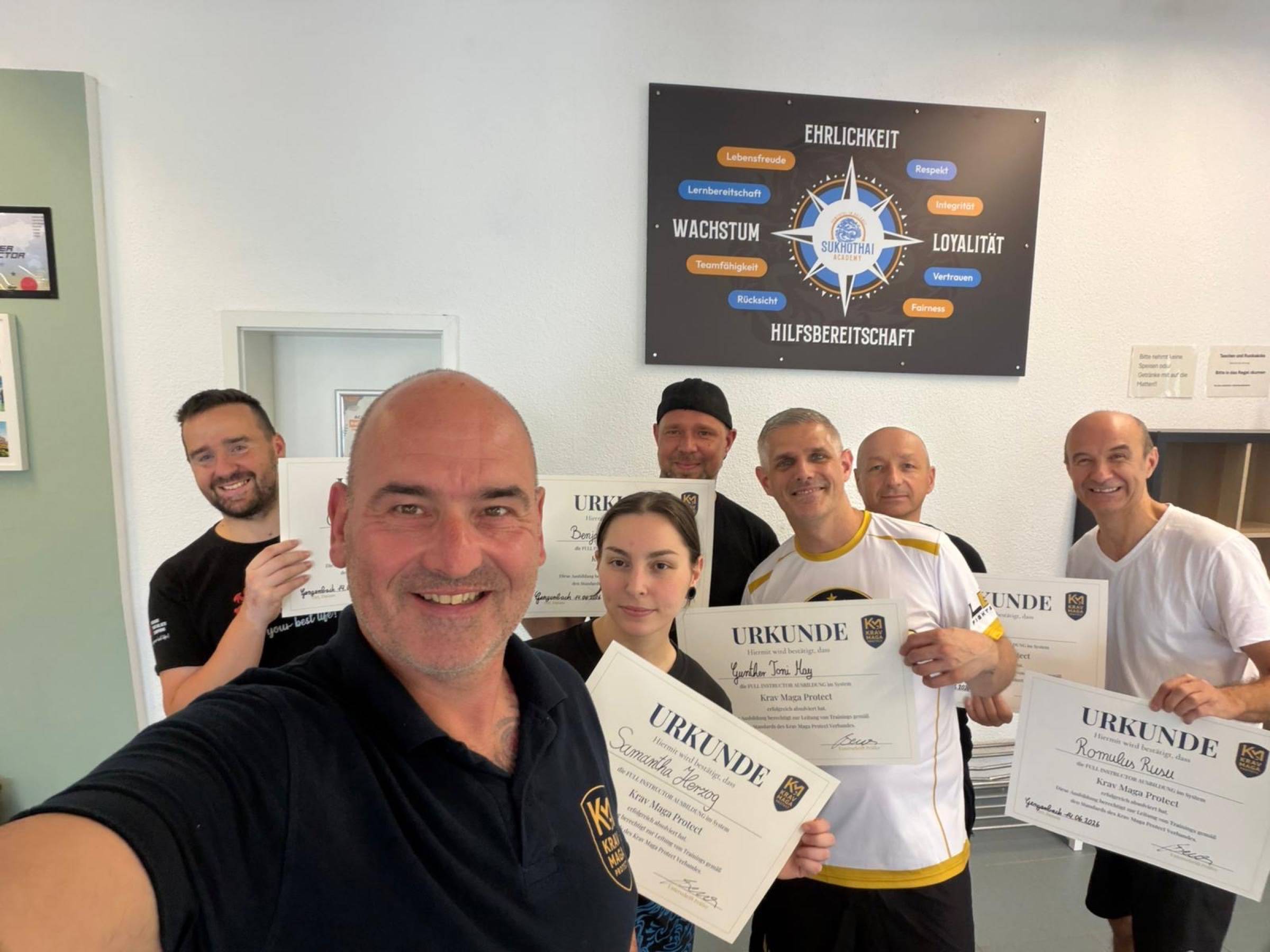 Christian Benz von Krav Maga Protect mit Absolventen seiner Ausbildung, alle halten ihre Urkunden