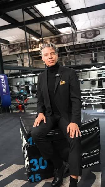 Klaus Nonnemacher im Anzug, sitzend im Boxstudio
